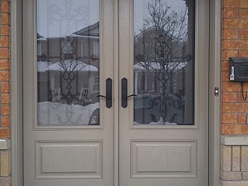Double steel doors with wrought iron glass inserts and EMTEK lock